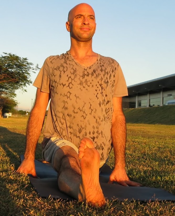Jonathan in a seated yoga pose outdoors at sunset