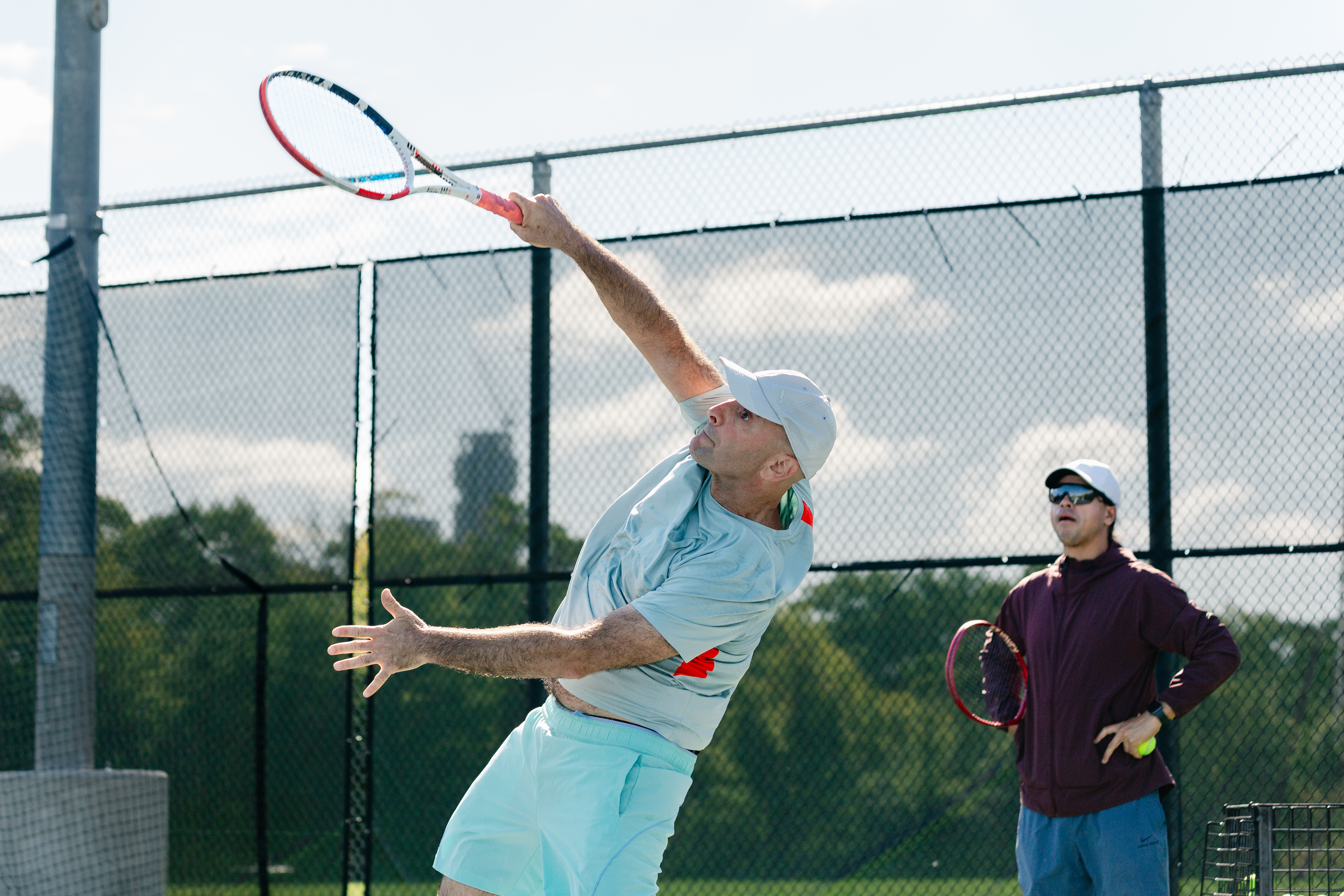 Jonathan serving on a tennis court